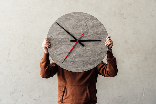 A person holds up a clock